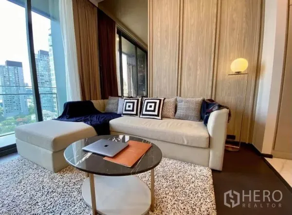 公寓 出租在Watthana, Bangkok - 舒适客厅，沙发与圆形茶几，毗邻阳台。