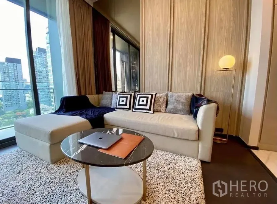 公寓 出租在Watthana, Bangkok - 舒适客厅，沙发与圆形茶几，毗邻阳台。