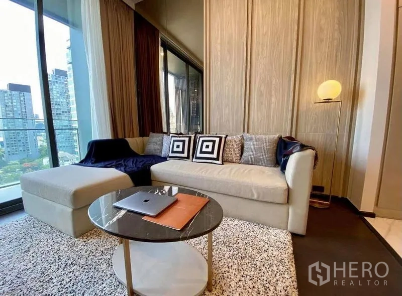 公寓 出租在Watthana, Bangkok - 舒适客厅，沙发与圆形茶几，毗邻阳台。