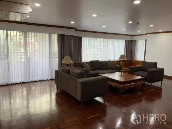 公寓 出租在Watthana, Bangkok - 转角客厅带落地窗与薄纱窗帘，深色木地板，Liberty Park 1 素坤逸23。