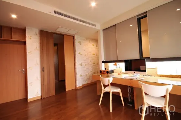 Condominium for rent or sale in Khlong Toei, Bangkok - Bright study with a long built-in desk, wood floors, and sliding doors.