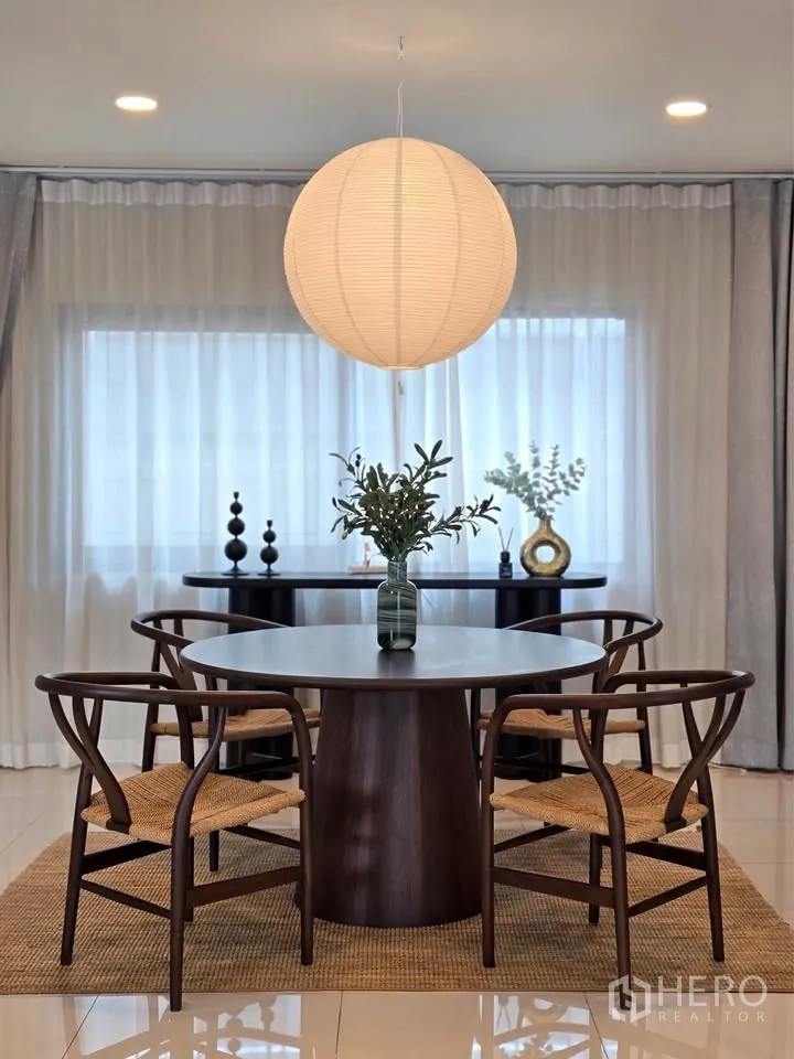 Detached House for rent or sale in Bang Phli, Samut Prakan - Dining room centered under a globe pendant with round table and four chairs.