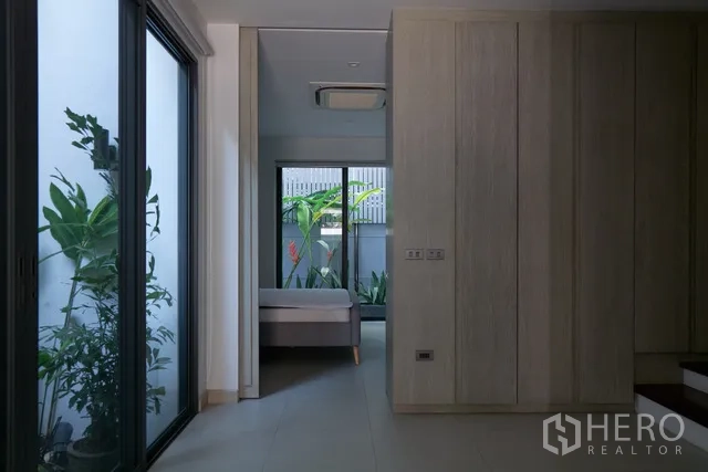 联排别墅 出租在Watthana, Bangkok - 走廊带推拉玻璃，通向两侧庭院与卧室。