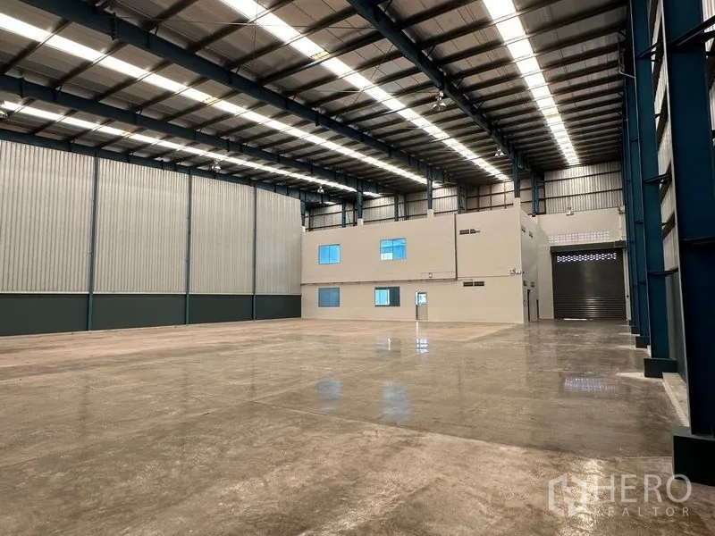 Factory for rent in Bang Phli, Samut Prakan - Warehouse hall featuring an integrated office block, skylights and a large roller door.