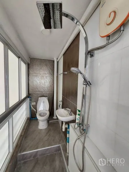 Condominium for rent or sale in Khlong Toei, Bangkok - Secondary bathroom with rain shower, toilet and small sink in an enclosed space.