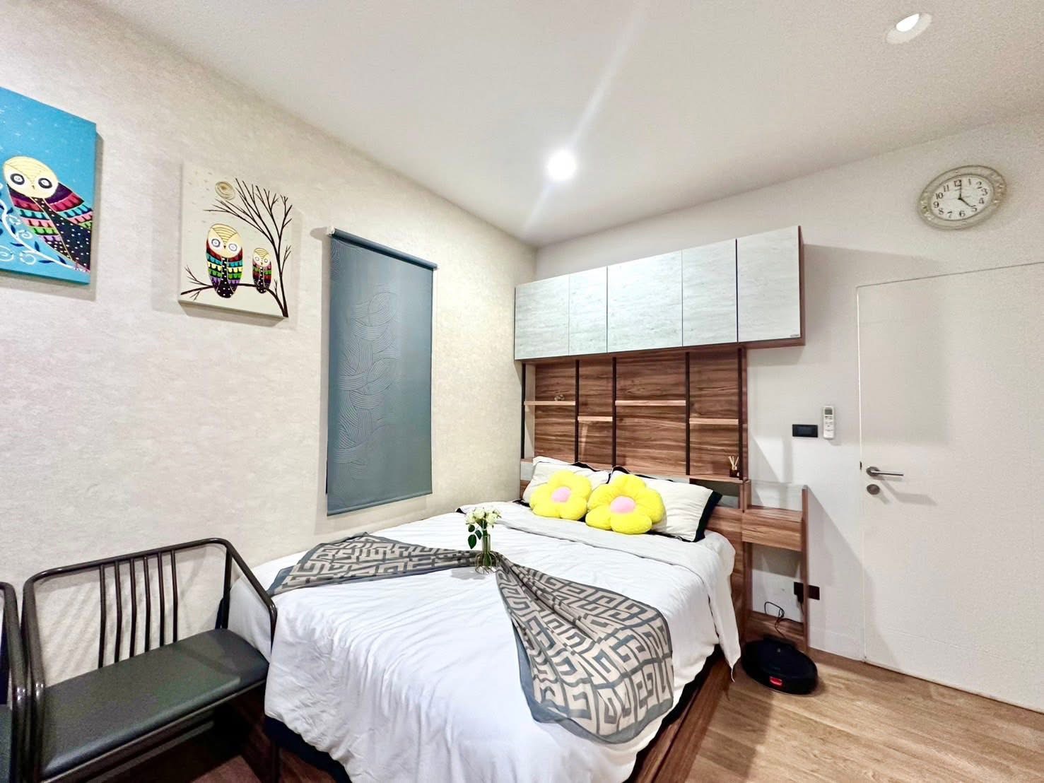 Detached House for rent in Bang Kapi, Bangkok - Compact guest bedroom with built-in headboard, wall cabinets and playful artwork.