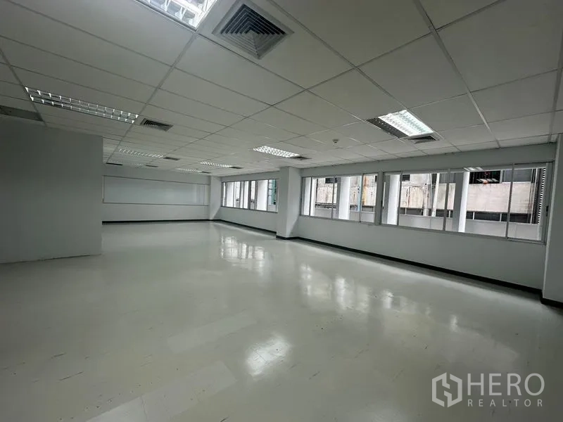 Office Space for rent in Bang Rak, Bangkok - Open office space with wide windows, grid ceiling, and built-in lighting for even illumination.