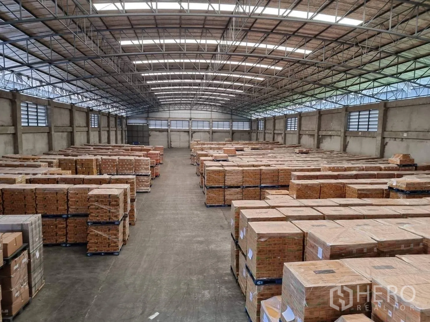 工厂 出租或出售在Pathum Thani - 高屋顶下的宽阔过道与两侧托盘货物