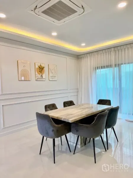 独立式住宅 出租在Bang Phli, Samut Prakan - 餐厅配大理石餐桌六椅，吊顶嵌入式空调与纱帘。