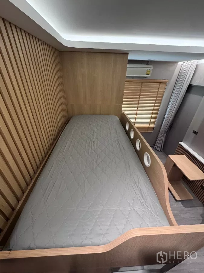 Townhouse for rent or sale in Lat Phrao, Bangkok - Upper bunk platform with round porthole details and wood slat wall.