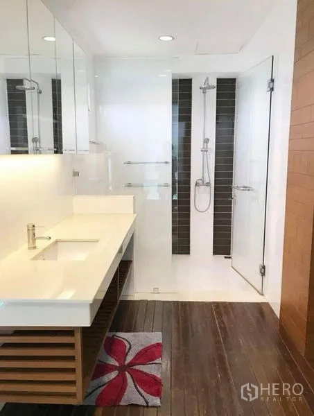 Townhouse for rent in Wang Thonglang, Bangkok - Contemporary bathroom with long vanity, glass shower and wood-look flooring.