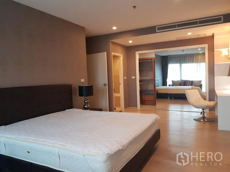 Condominium for rent in Khlong Toei, Bangkok - Bedroom with king bed, mirrored wardrobe, study nook and warm ambient lighting.