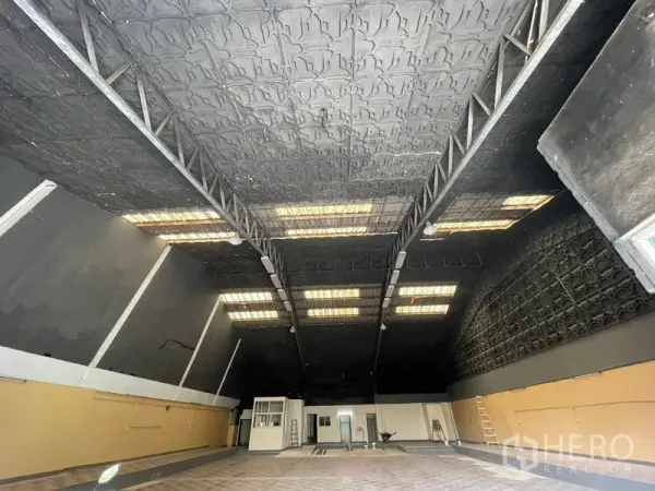 Warehouse for rent in Sam Phran, Nakhon Pathom - Spacious warehouse interior with high steel-truss ceiling and skylight panels.