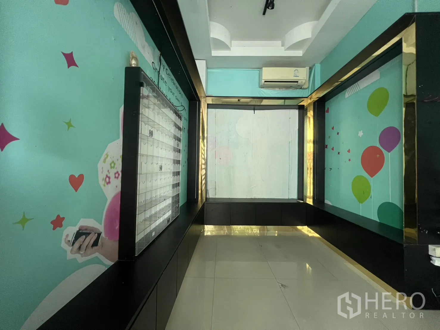 พื้นที่ขายของ for rent in Watthana, Bangkok - ห้องแคบยาวผนังสีเขียวฟ้า กรอบอลูมิเนียมสีดำ มีแอร์แขวนผนังและพื้นกระเบื้อง
