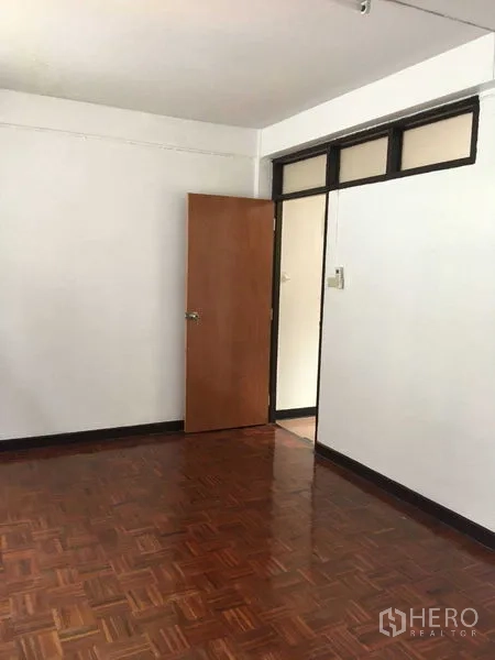 联排别墅 出租在Phra Khanong, Bangkok - 卧室一角，木地板与木门。