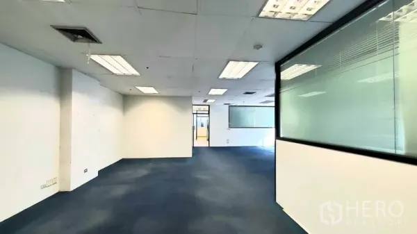 办公空间 出租在Khlong Toei, Bangkok - 开放式办公室，蓝色地毯、吊顶灯具和室内玻璃隔断。