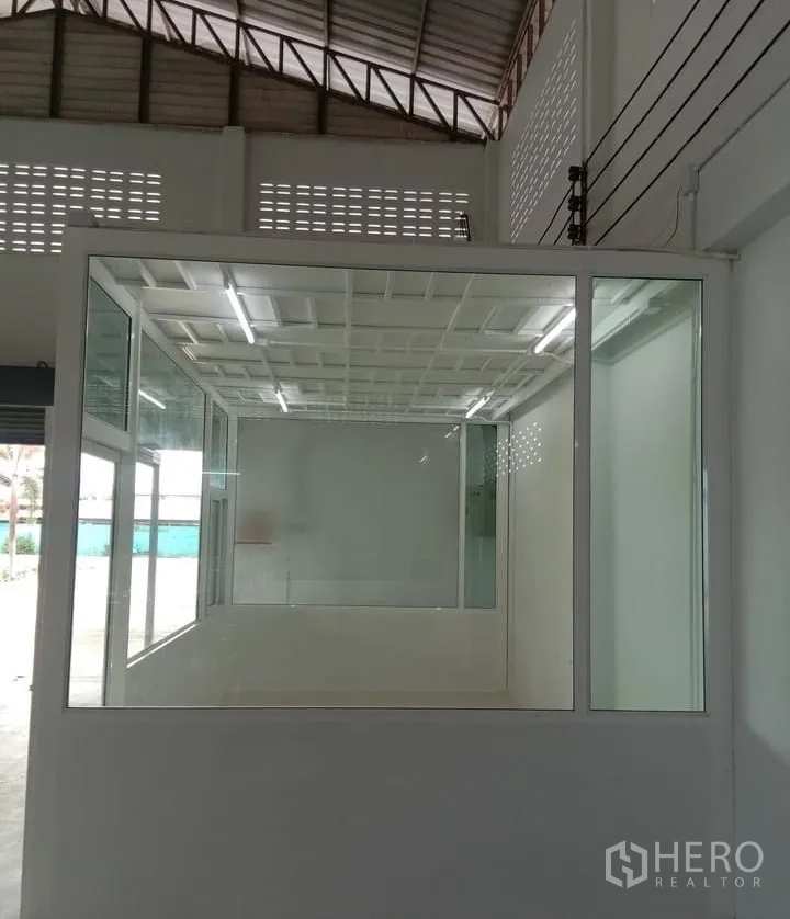 Factory for rent in Lat Lum Kaeo, Pathum Thani - Glass-partitioned office room inside the production hall with bright fluorescent lighting.