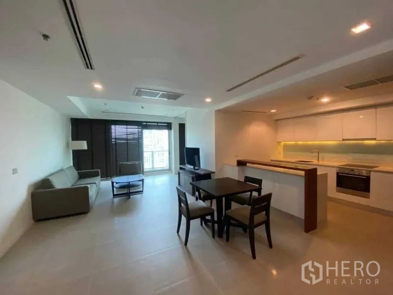 公寓 出租在Khlong San, Bangkok - 开放式客厅，设沙发、电视、餐桌与带吧台的橱柜式厨房。