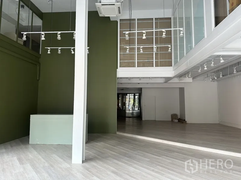 Retail Space for rent in Khlong Toei, Bangkok - Main hall with high ceiling, hanging spotlights and upper glass-partitioned rooms.