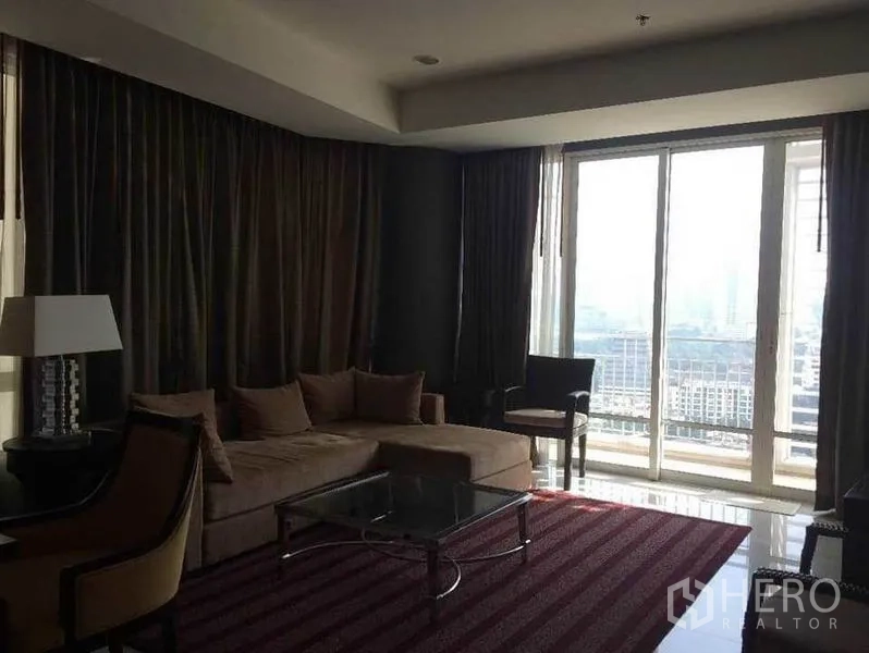 公寓 出售在Pathum Wan, Bangkok - 客厅设转角沙发、玻璃茶几与落地窗。