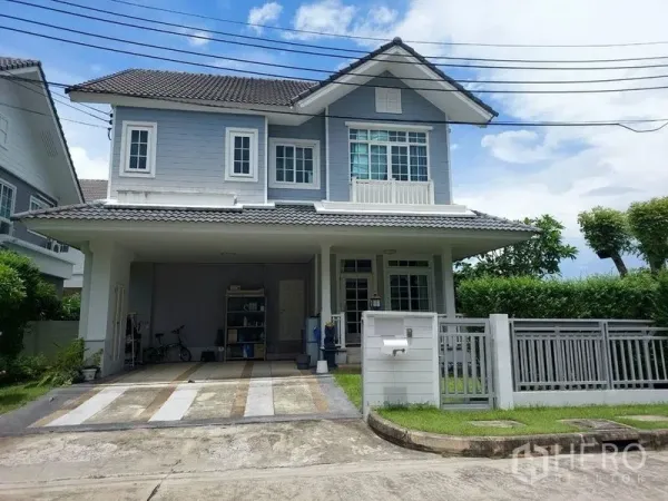 独立式住宅 出售在Khlong Sam Wa, Bangkok - 两层独栋住宅，带车棚、前院草坪与围栏大门。