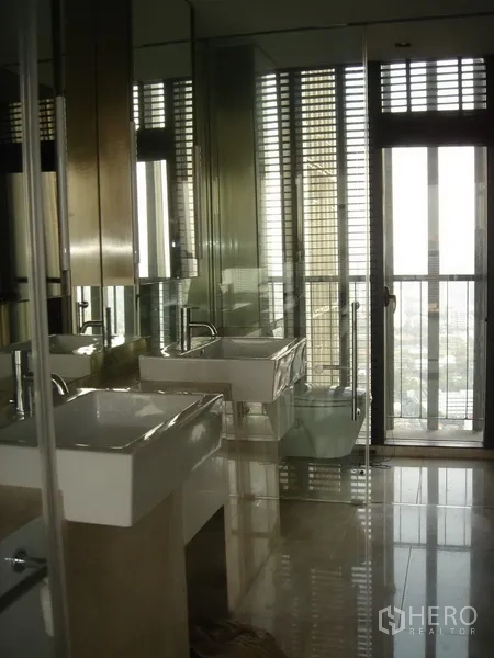 Condominium for rent in Sathon, Bangkok - Bright bathroom with twin basins, large mirrors and glass door.