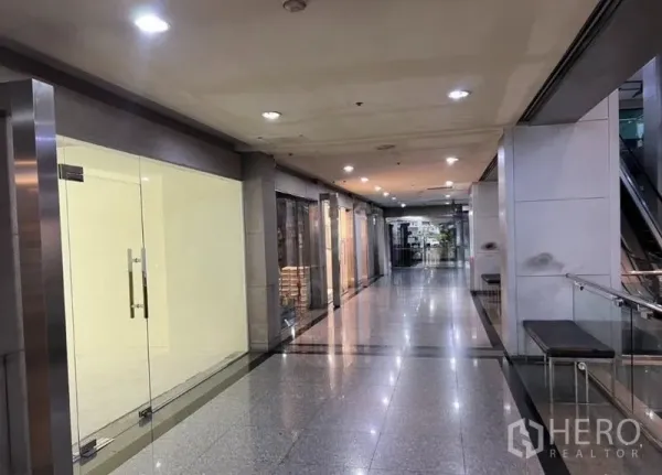 Retail Space for rent in Watthana, Bangkok - Commercial hallway with escalator access and multiple retail units in a modern building.