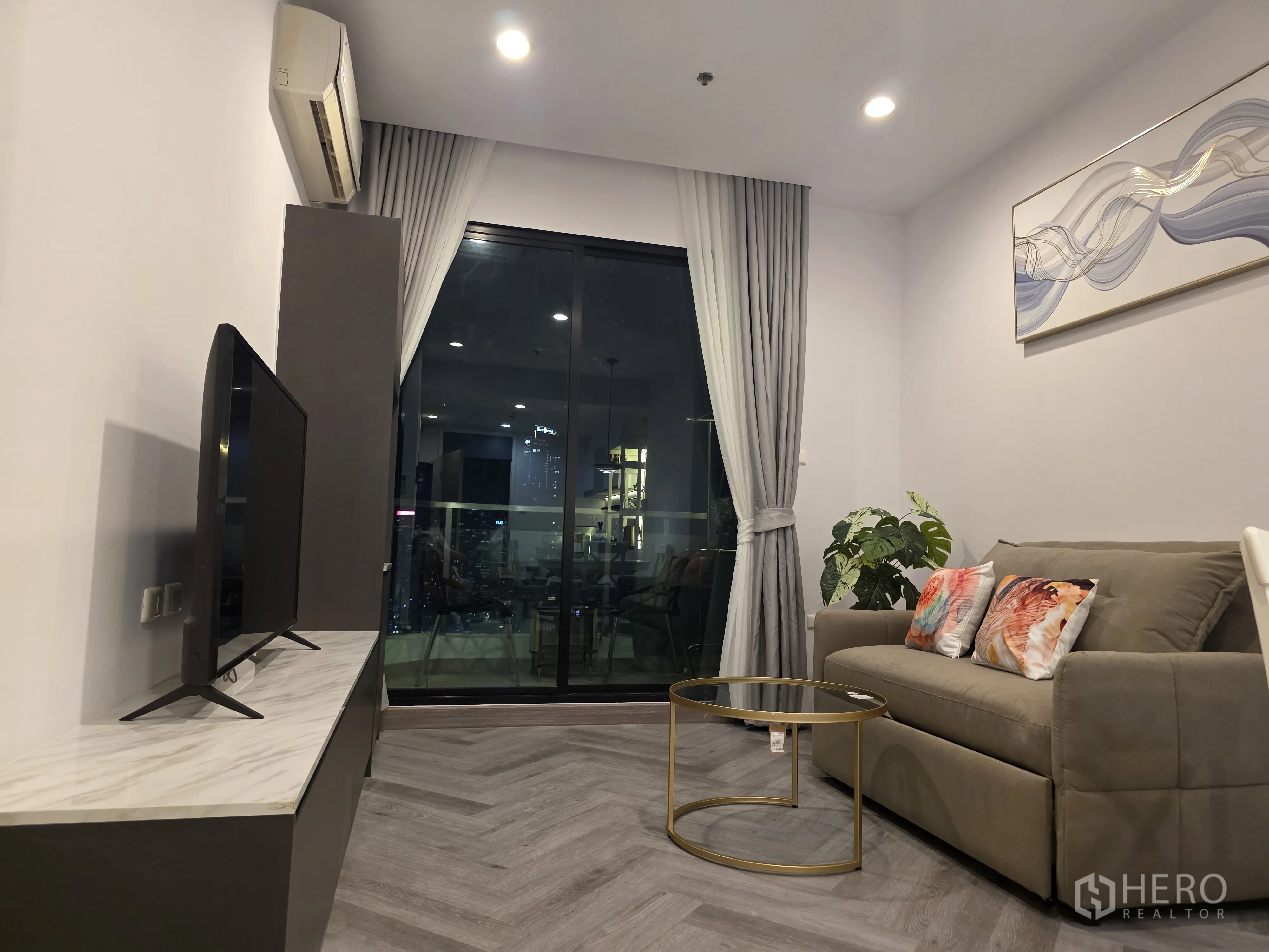 公寓 for rent in Bang Kapi, Bangkok - 客厅内有沙发、电视柜与大面积推拉玻璃门。