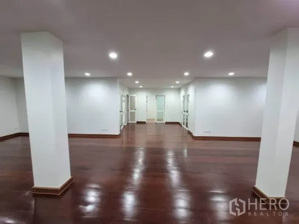 店屋 出租在Bang Rak, Bangkok - 开放式商业空间，木地板、顶灯、立柱及多扇玻璃门。