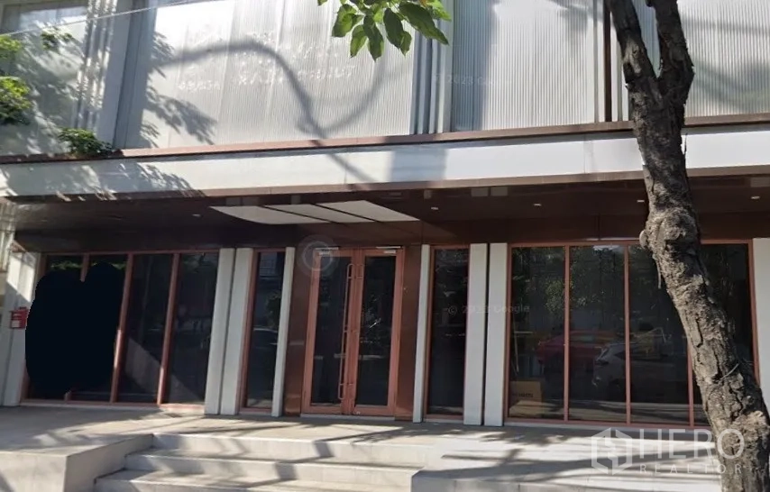 店屋 出租在Phra Khanong, Bangkok - Phra Khanong 现代店屋外立面，整面玻璃门面与有遮檐的入口台阶。
