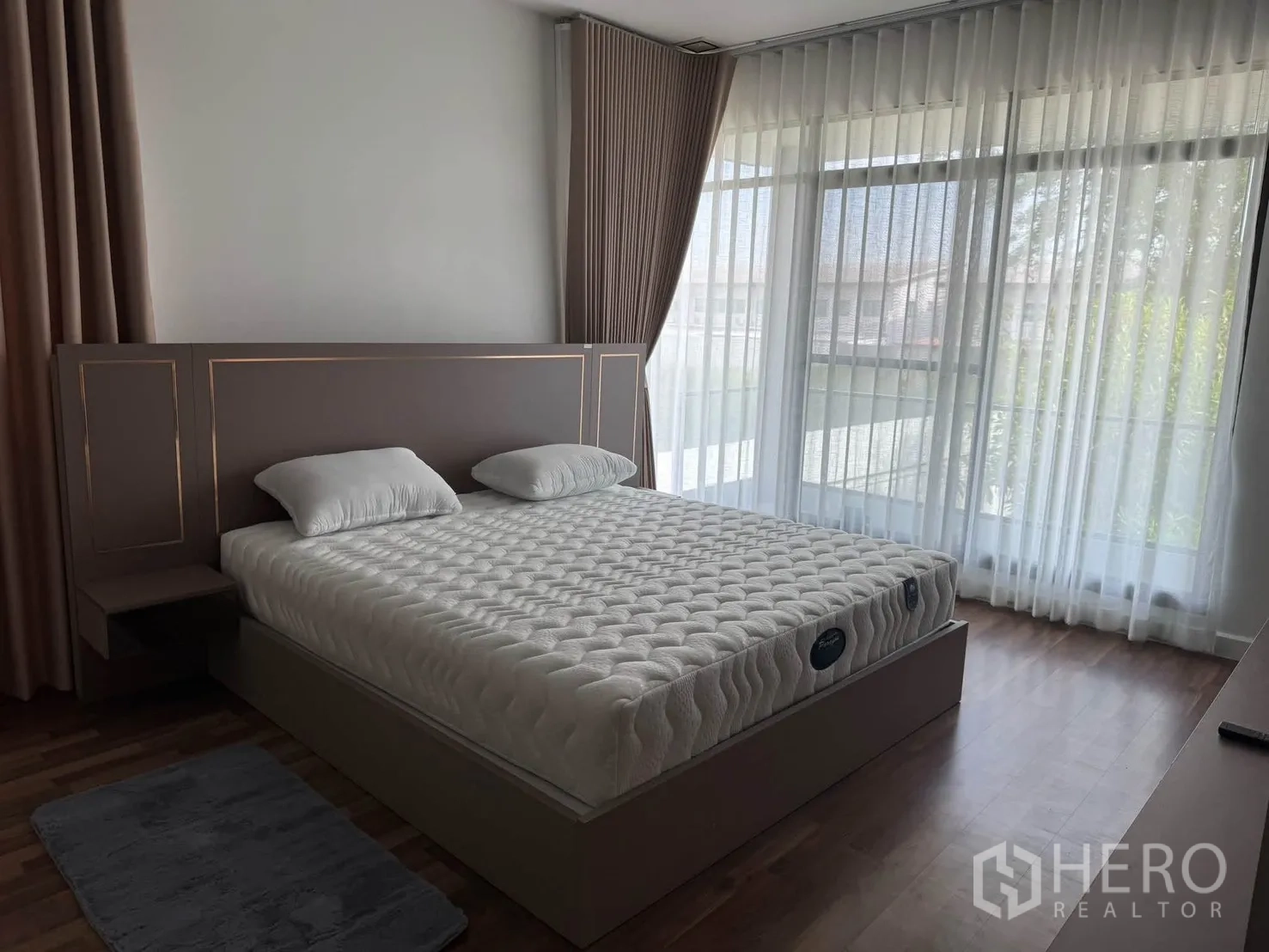 Detached House for rent in Prawet, Bangkok - Bedroom with a large bed, floor-to-ceiling windows, and layered curtains.
