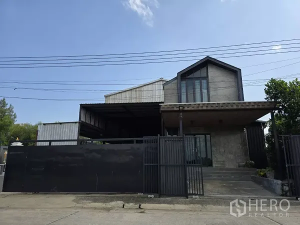 货栈 出售在Lat Lum Kaeo, Pathum Thani - Lat Lum Kaeo街景仓库外观，带大门围栏与两层办公立面及金属屋顶。