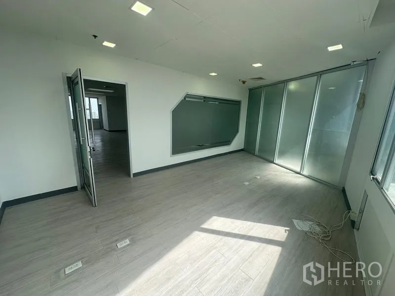 Office Space for rent - Glazed corridor on a high floor with polished black tiles and floor-to-ceiling windows.