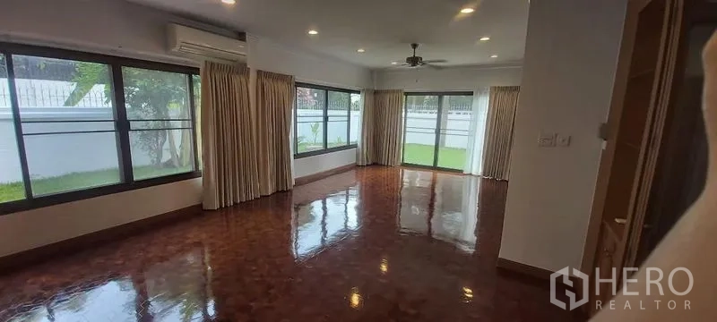 独立式住宅 出租在Pathum Wan, Bangkok - 宽敞客厅，落地窗与窗帘，亮面木地板