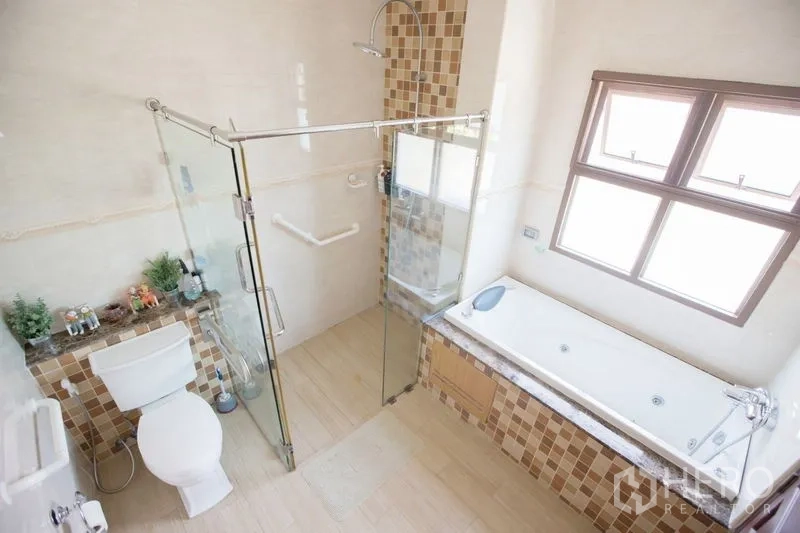 Detached House for sale in Lat Krabang, Bangkok - Master bathroom featuring glass shower, soaking bathtub, window and mosaic tiles.