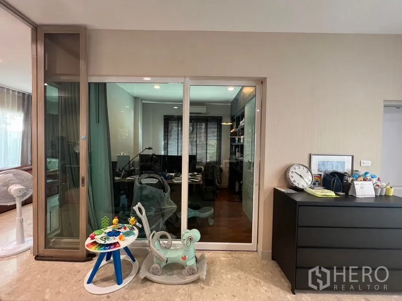 Detached House for rent or sale in Saphan Sung, Bangkok - Glass-enclosed home office with built-in shelves and window blinds.