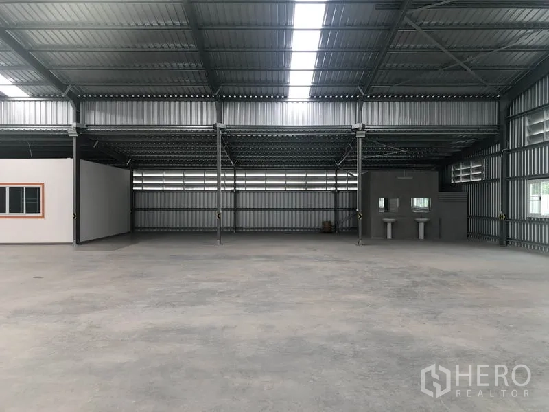Warehouse for rent in Mueang Nonthaburi, Nonthaburi - Warehouse interior facing the utility zone with sinks next to the restroom area.