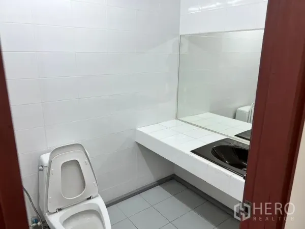สำนักงาน ให้เช่าในPathum Wan, Bangkok - ห้องน้ำสำนักงานสะอาด ผนังกระเบื้องสีขาว โถสุขภัณฑ์ และเคาน์เตอร์อ่างล้างหน้าพร้อมกระจกบานใหญ่.
