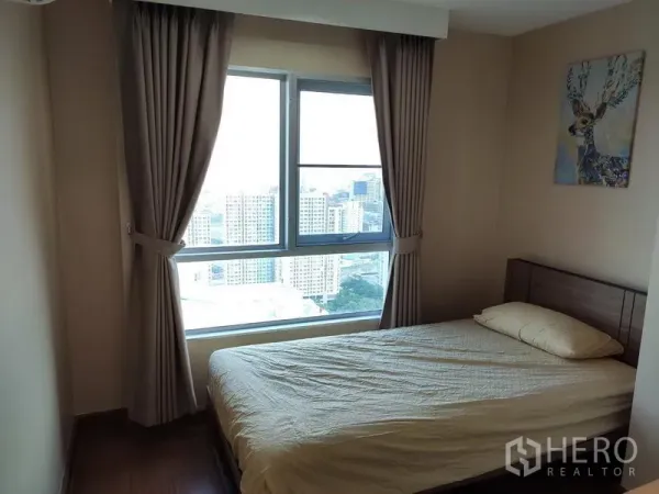 คอนโด ให้เช่าในHuai Khwang, Bangkok - ห้องนอนพร้อมหน้าต่างบานใหญ่เห็นวิวเมือง ผ้าม่านทึบ โทนสีอบอุ่น