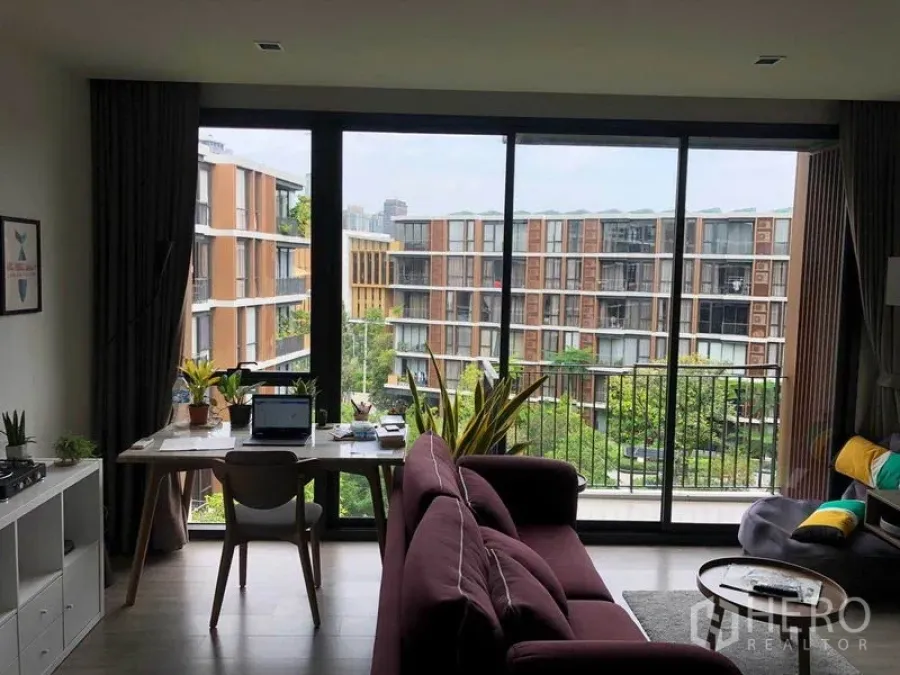 公寓 出租在Watthana, Bangkok - 客厅落地窗连接阳台，眺望郁郁葱葱的中庭景观。
