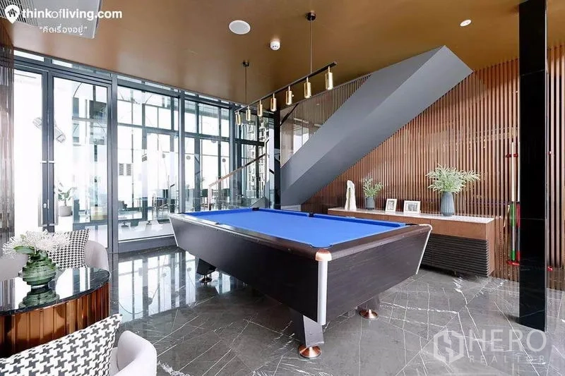 Condominium for rent in Watthana, Bangkok - Residents’ game room with blue felt pool table, glass walls and pendant lighting.