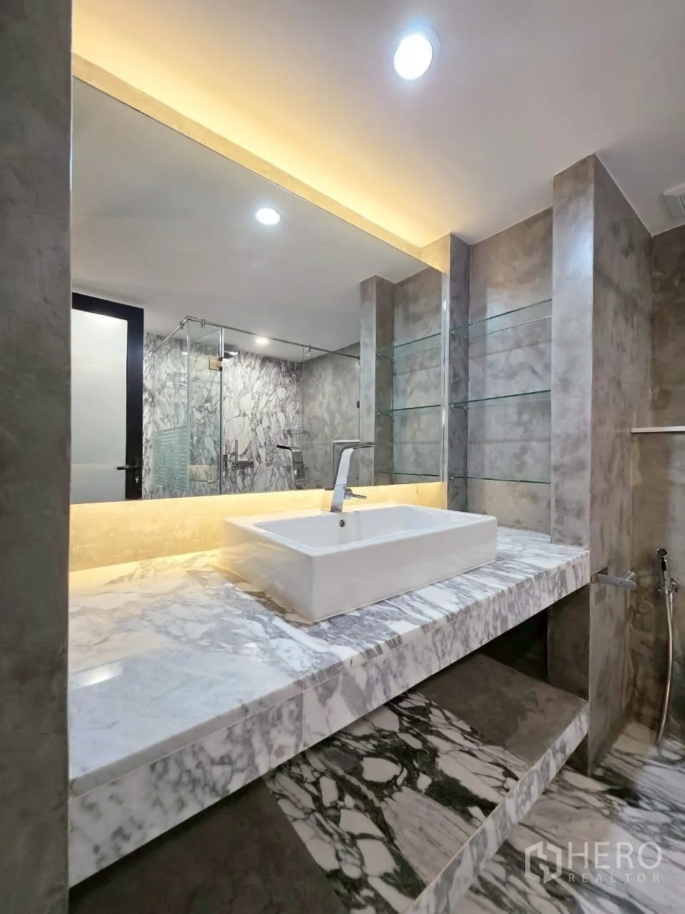 Condominium for rent in Sathon, Bangkok - Luxurious bathroom with marble vanity, large mirror and warm ambient lighting.