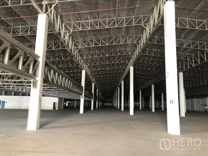 货栈 出租在Lam Luk Ka, Pathum Thani - 仓库中央通道纵深视角，多根立柱与大面积地坪
