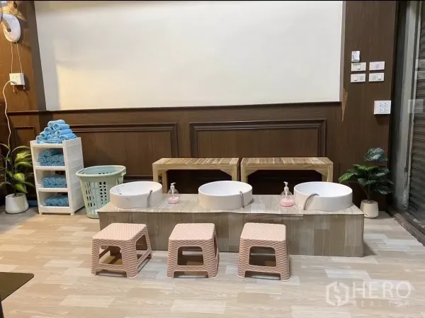 Shophouse for rent in Watthana, Bangkok - Pedicure station with foot basins, small stools and towel storage on wood flooring.