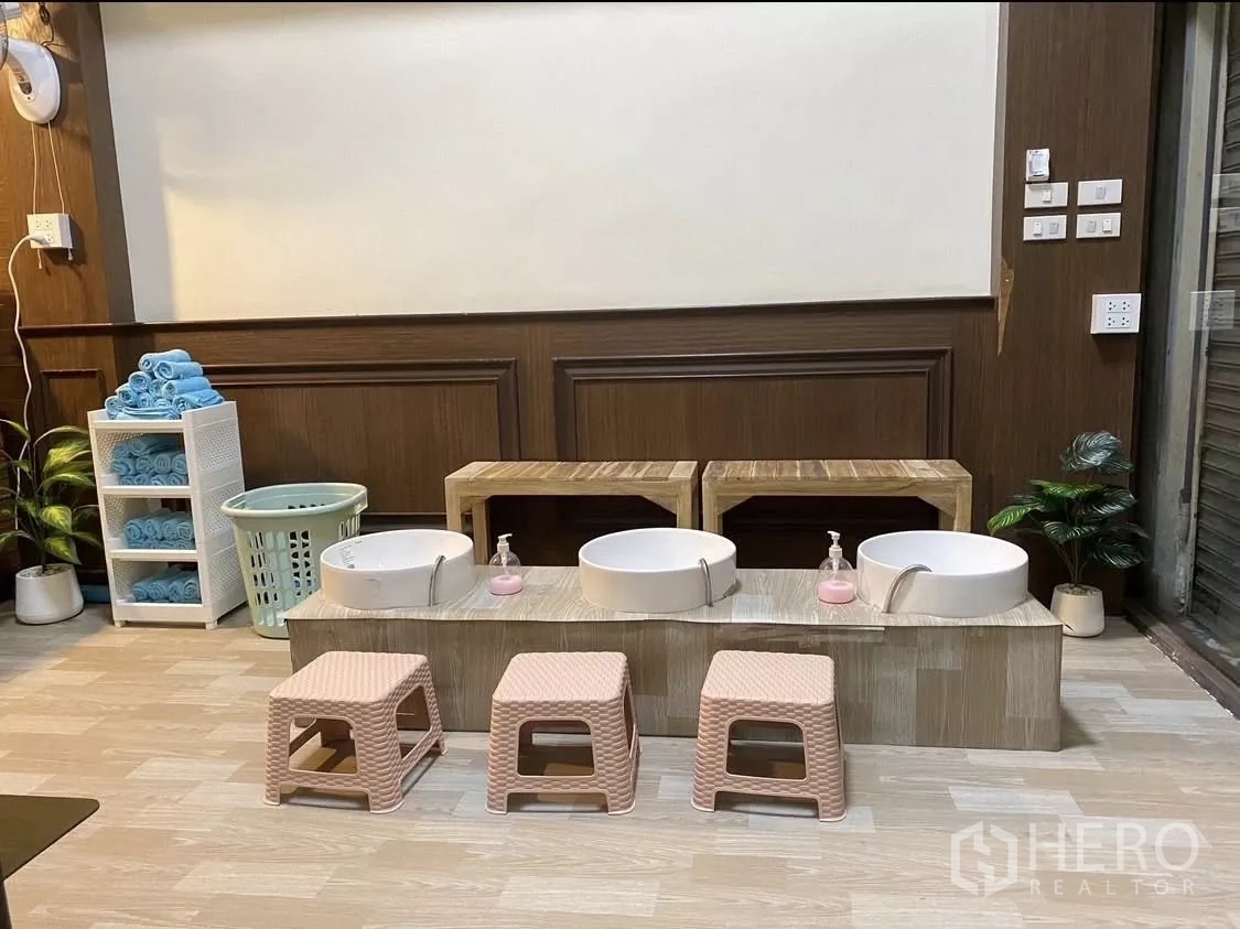 Shophouse for rent in Watthana, Bangkok - Pedicure station with foot basins, small stools and towel storage on wood flooring.