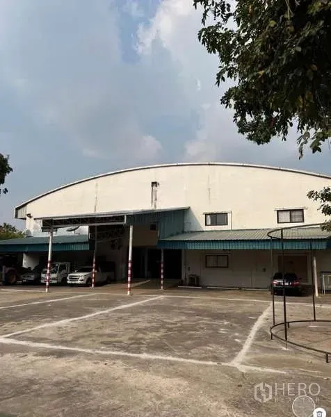 คลังสินค้า ขายในBang Bua Thong, Nonthaburi - ด้านหน้าโกดังหลังคาโค้งพร้อมหลังคาคลุมจุดขนถ่ายและลานคอนกรีตกว้าง บางบัวทอง.