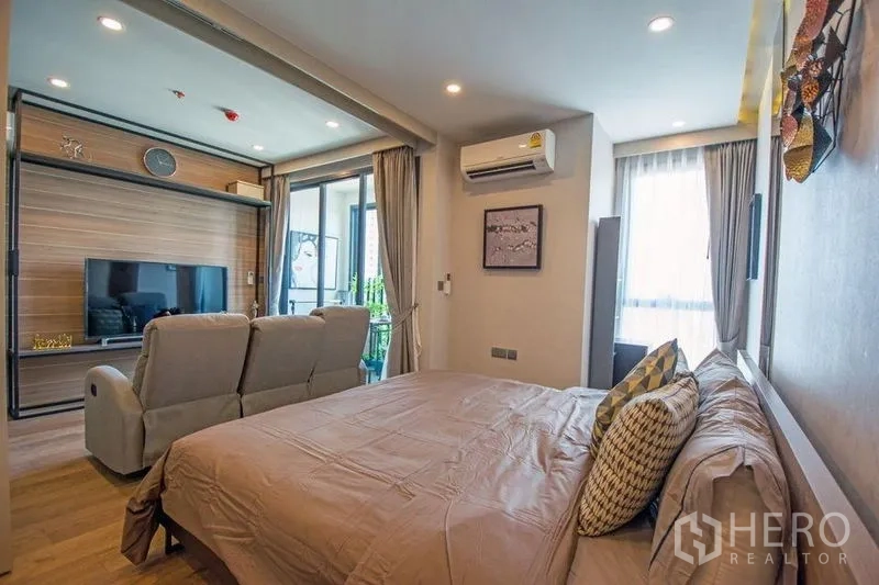 公寓 出售在Ratchathewi, Bangkok - 卧室望向客厅的视角，见电视墙、阳台与空调