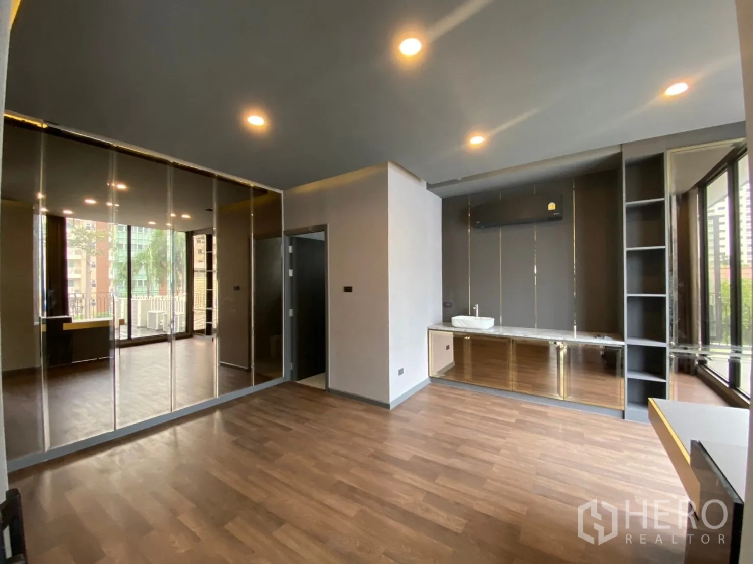 带办公室的家 出租或出售在Watthana, Bangkok - 现代家用办公房间，木地板、镜面收纳柜、带水槽的操作台与大落地窗。
