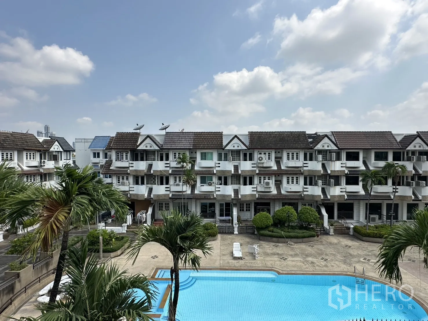 家庭办公室 for rent in Watthana, Bangkok - 俯瞰公共泳池与周边联排住宅的景观。