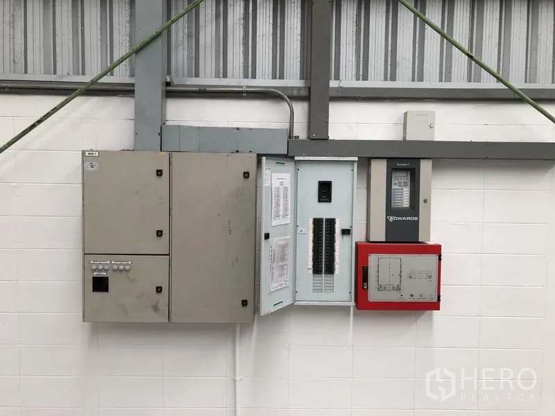 Factory for rent in Bang Sao Thong, Samut Prakan - Industrial electrical control panels and fire alarm system mounted on the wall.